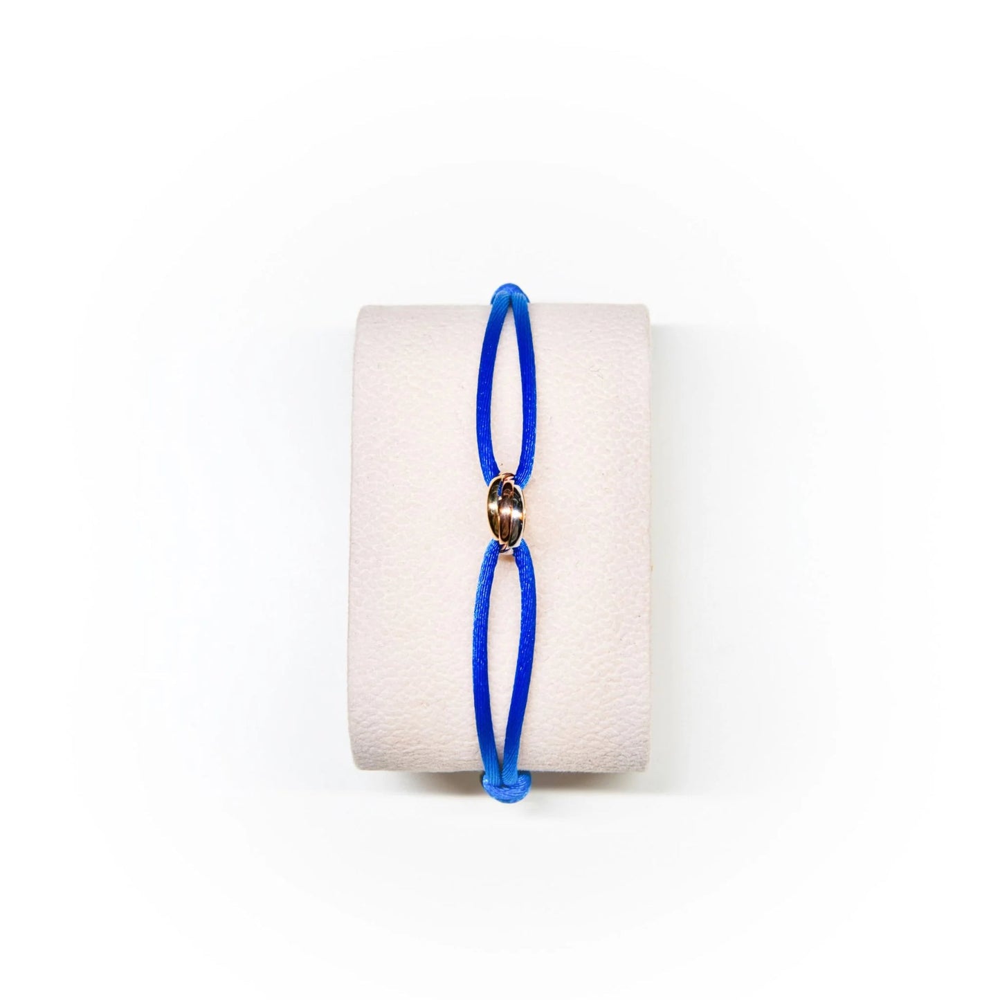 Blue bracelet on a white cylindrical stand with a white background