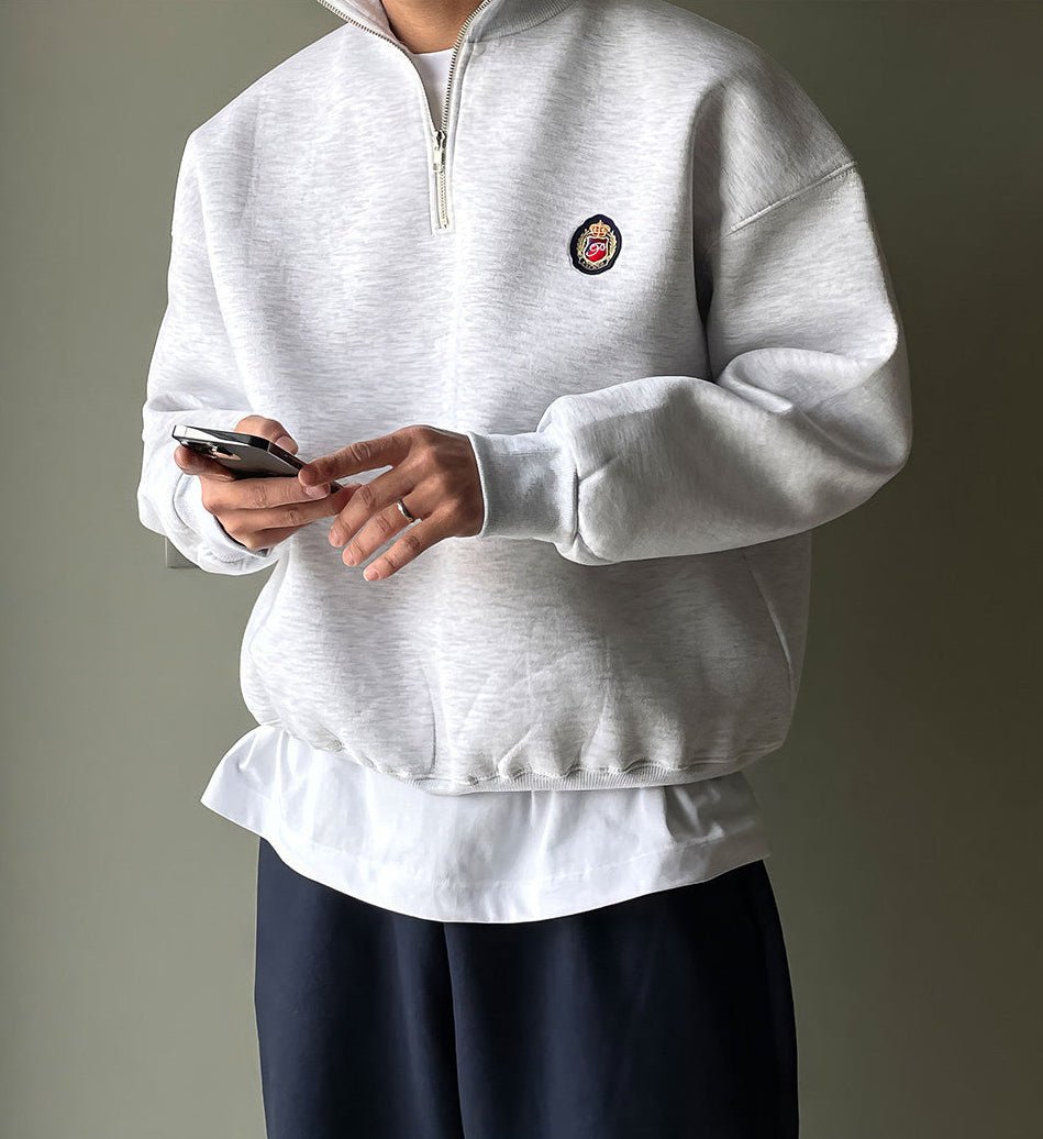 Men's gray high-neck quarter-zip sweatshirt featuring a loose fit, dropped shoulders, and a structured collar.
