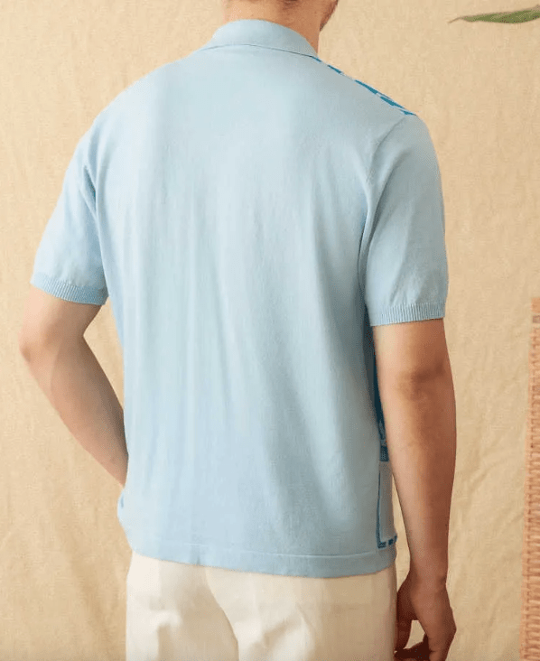 Men's light blue button-through knitted polo featuring a front pocket and white striped trim on the collar and cuffs.