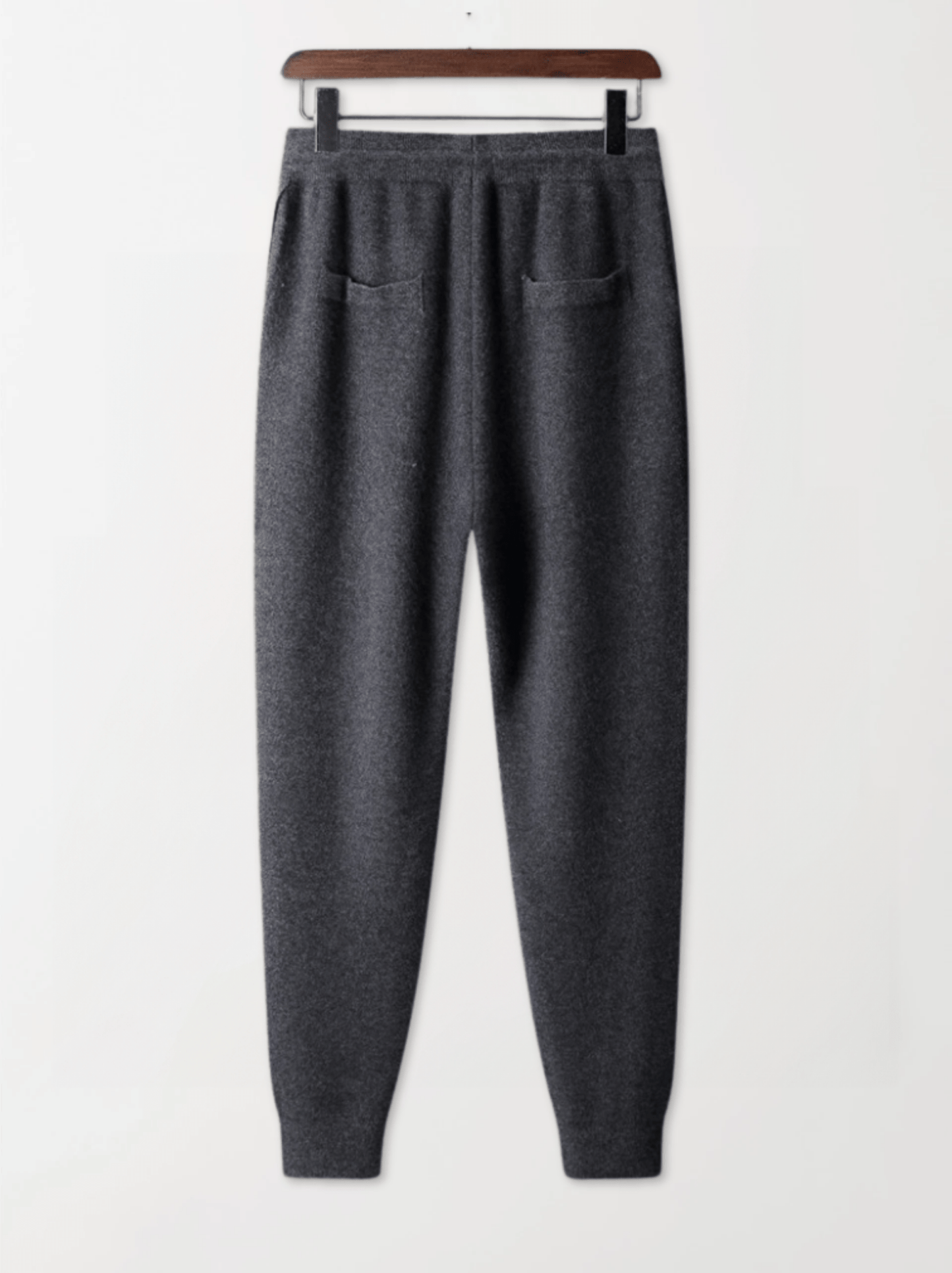 Gray sweatpants on a hanger against a white background