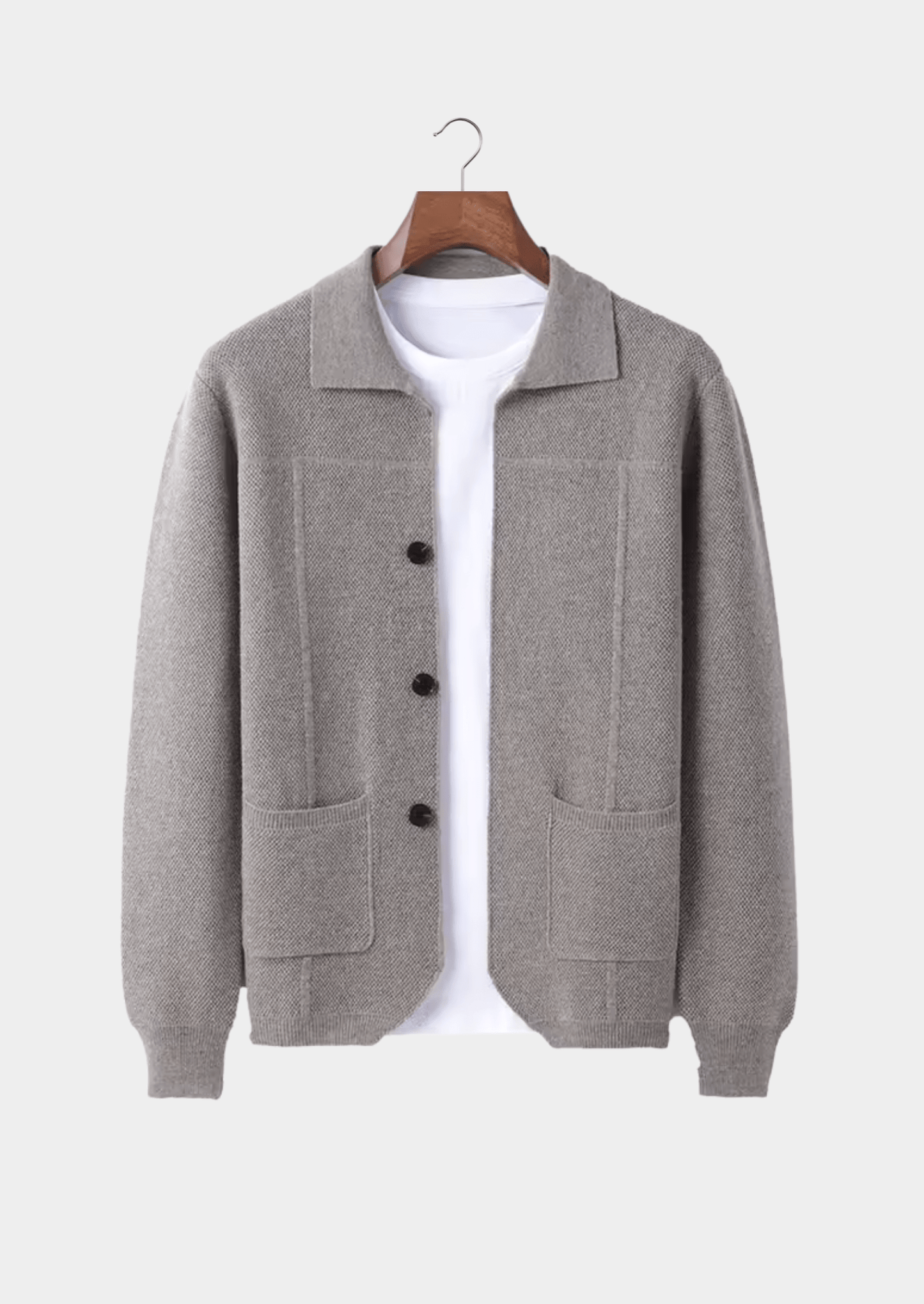 Gray cardigan on a hanger against a white background