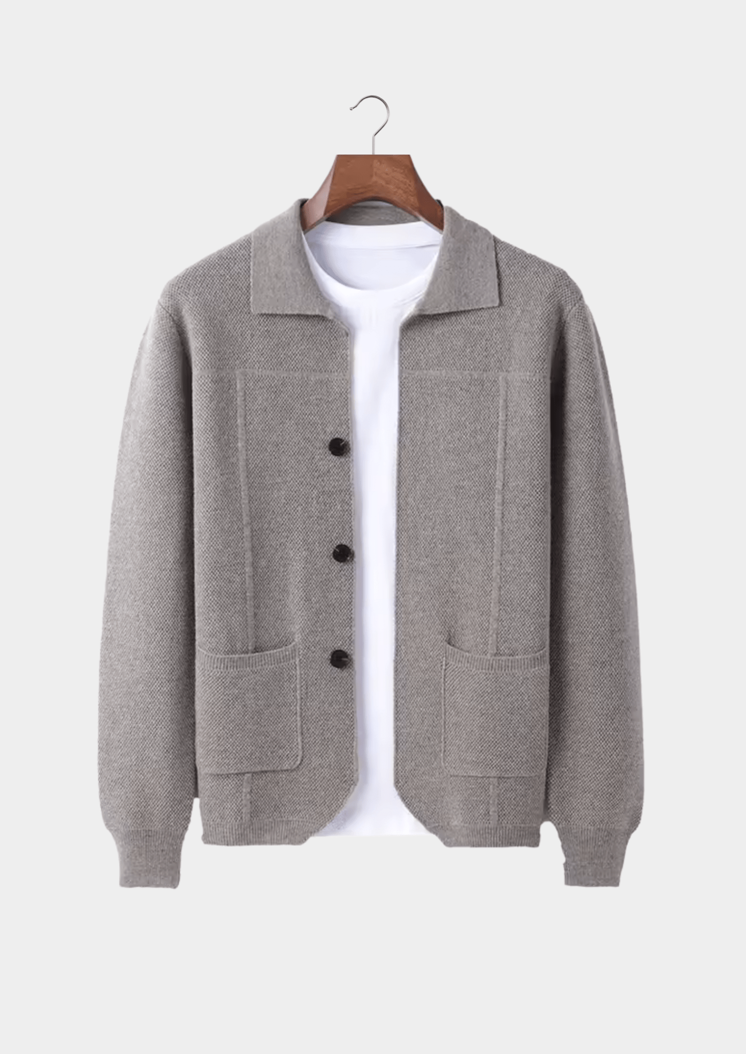 Gray cardigan on a hanger against a white background