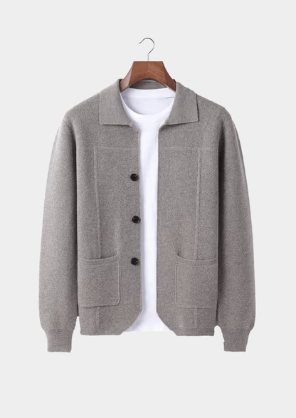 Gray cardigan on a hanger against a white background