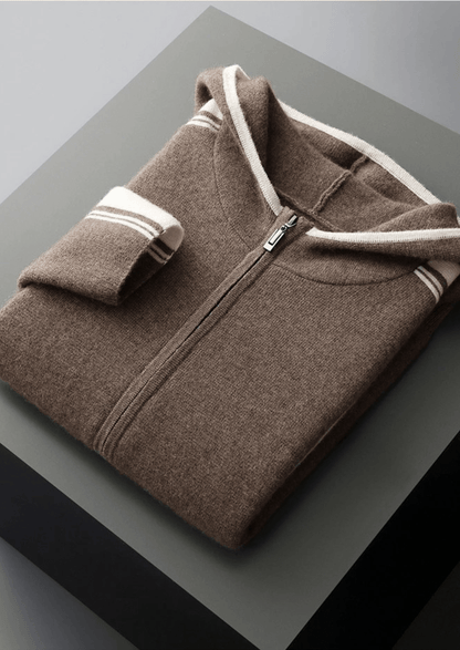 Folded brown fleece pullover with white trim on a gray surface