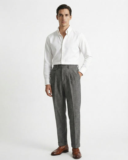 Man wearing grey houndstooth merino wool double pleated trousers with white dress shirt and leather loafers