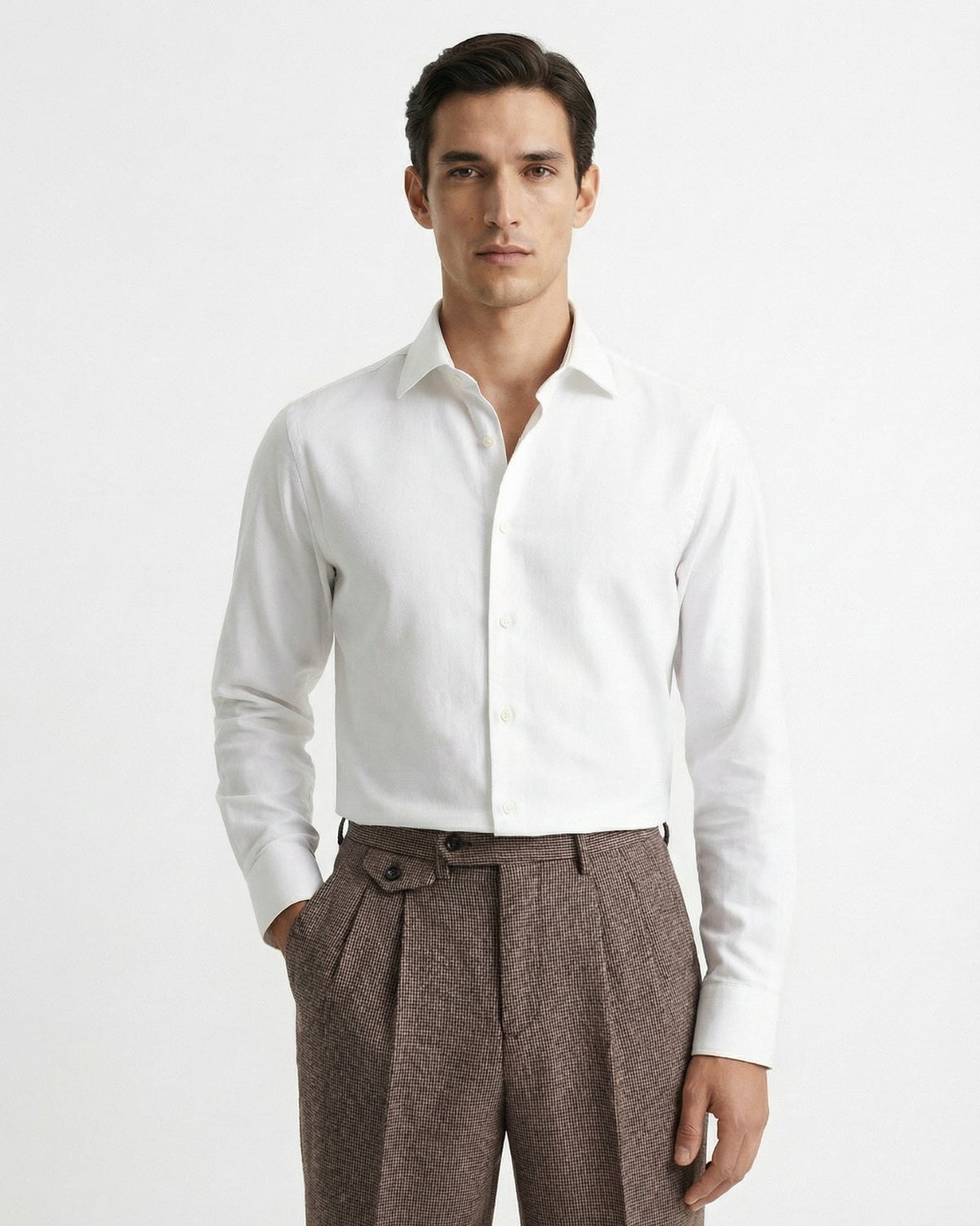 Man wearing brown houndstooth merino wool double pleated trousers with white dress shirt and leather loafers