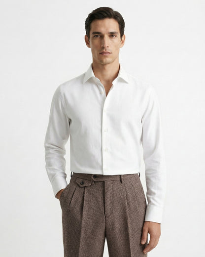 Man wearing brown houndstooth merino wool double pleated trousers with white dress shirt and leather loafers