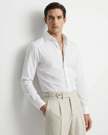 Man wearing a white dress shirt and beige pants against a light gray background