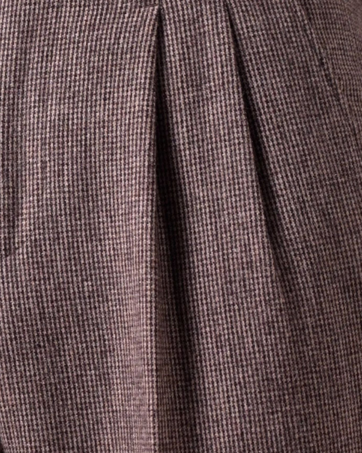 Close-up of brown houndstooth merino wool fabric texture focusing on double front pleat crease