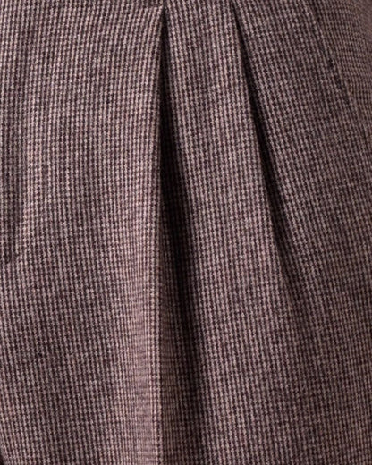 Close-up of brown houndstooth merino wool fabric texture focusing on double front pleat crease