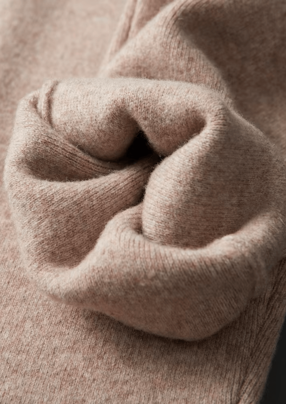 Close-up of a person wearing a beige sweater with a focus on the sleeve.
