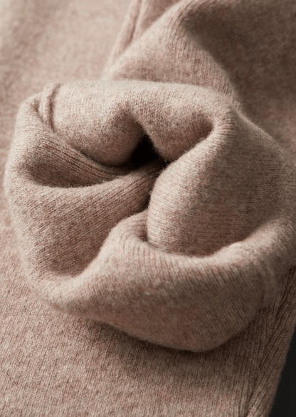 Close-up of a person wearing a beige sweater with a focus on the sleeve.