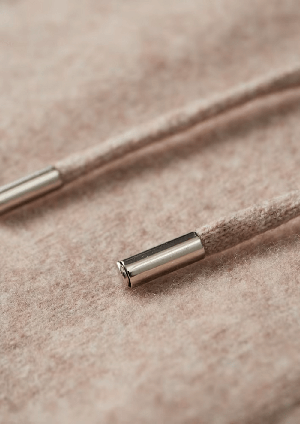 Close-up of a metal cable end cap on beige fabric