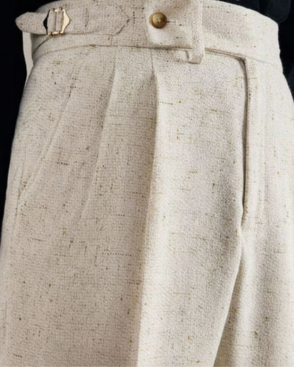 Close-up of LORMIER off-white linen trousers showing textured fabric, side adjuster buckle, and waistband button