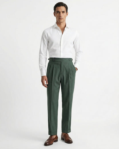 Men's forest green double-pleated cotton blend trousers showing extended crossover button waistband and side buckle