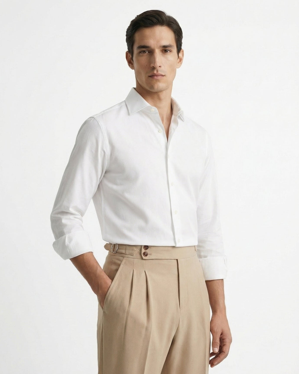 Men's beige double-pleated cotton blend trousers showing extended crossover button waistband and side buckle