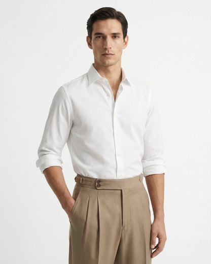 Men's beige double-pleated cotton blend trousers showing extended crossover button waistband and side buckle