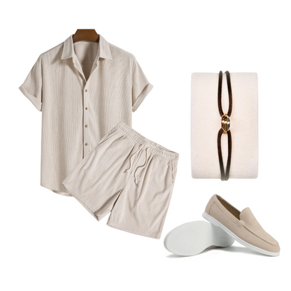 Beige shirt and shorts set with a necklace and loafers on a white background