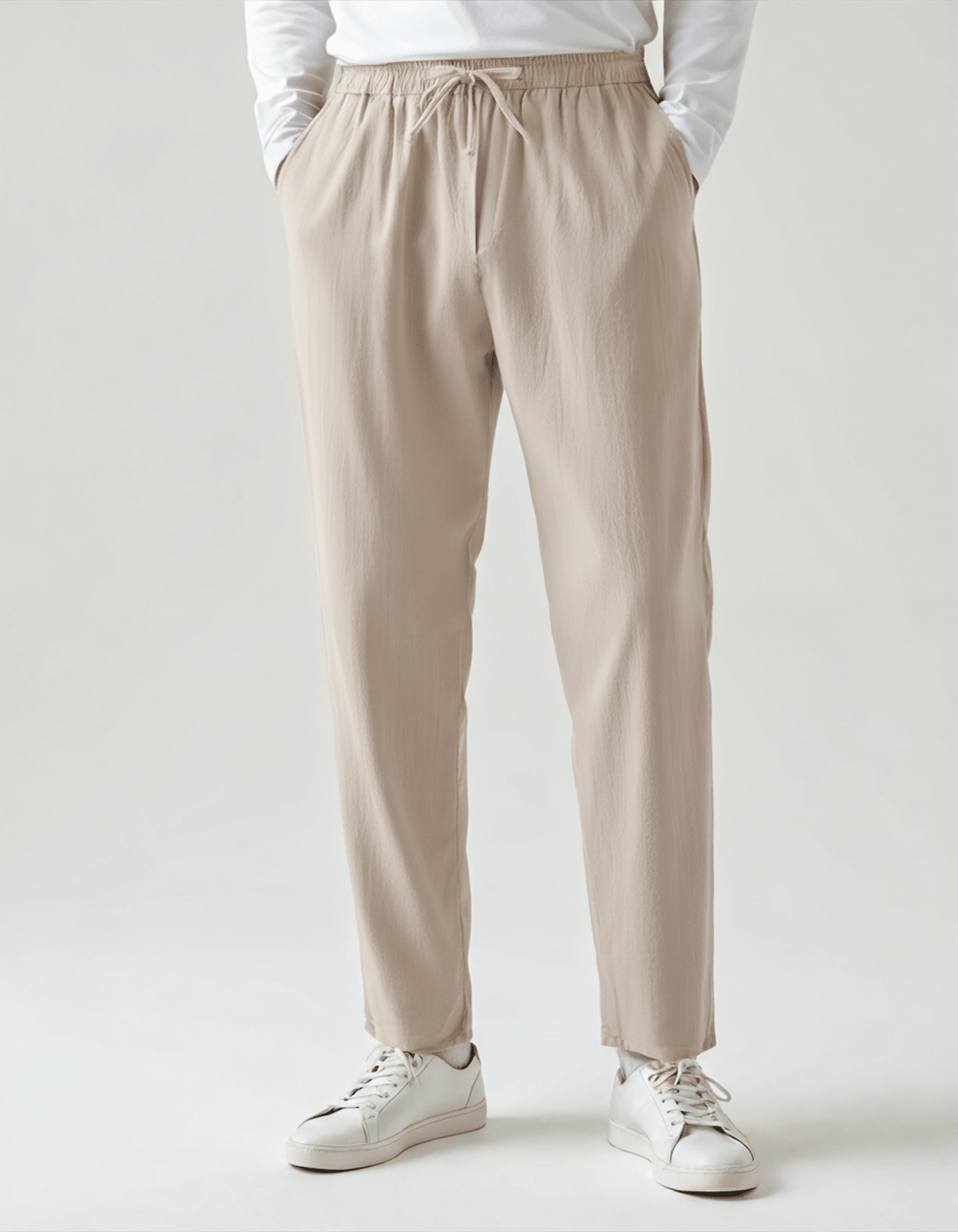 Men's beige relaxed linen pants featuring a comfortable elasticated drawstring waist and a tailored straight-leg silhouette.