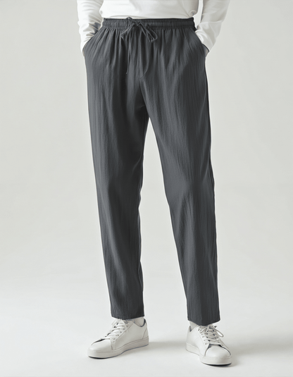 Men's charcoal gray linen trousers featuring a lightweight, moisture-wicking fabric and an ergonomic relaxed fit.