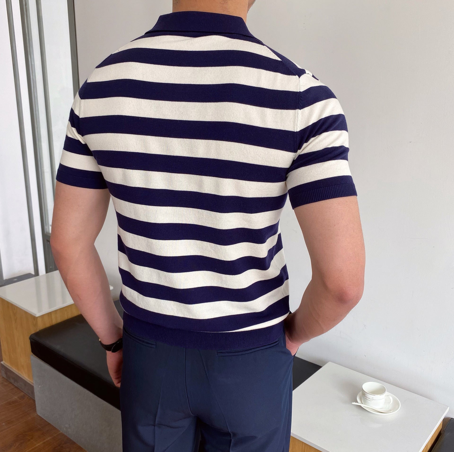 Men's navy and white horizontal Breton striped polo featuring a seamless open-collar design and a tailored slim fit.