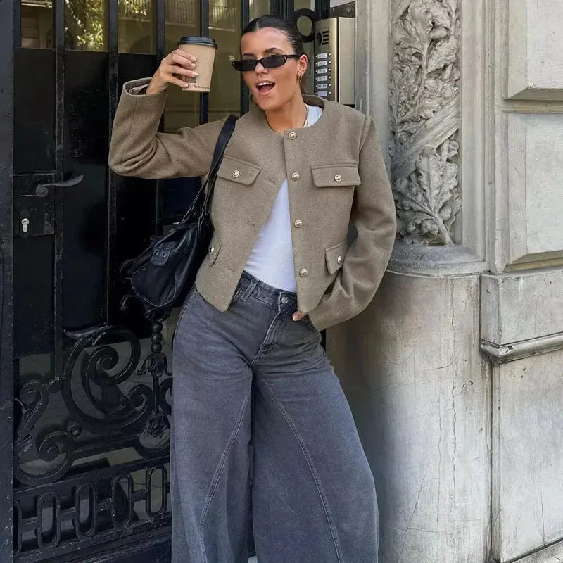 Model wearing a brown cropped textured jacket with gold buttons in a structured boxy fit