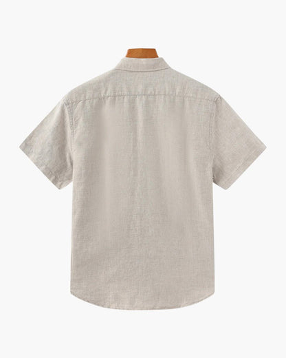 Men's beige short sleeve linen shirt featuring a natural slub texture, chest pocket, and a relaxed tailored fit.