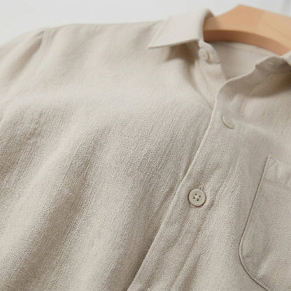 Men's beige short sleeve linen shirt featuring a natural slub texture, chest pocket, and a relaxed tailored fit.
