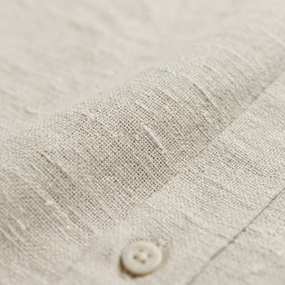 Men's beige short sleeve linen shirt featuring a natural slub texture, chest pocket, and a relaxed tailored fit.