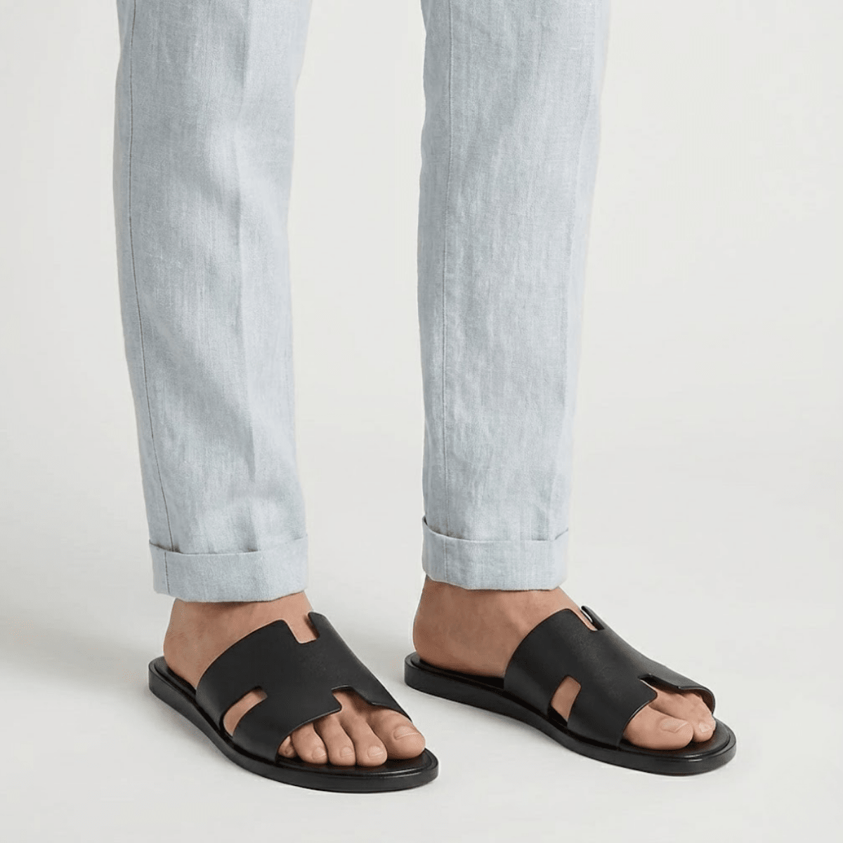 Men's black classic leather cross-strap sandals featuring a smooth finish and a padded comfort insole.