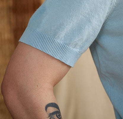 Men's light blue knit polo crafted from a breathable cotton-linen blend, featuring a classic button placket and ribbed hem.