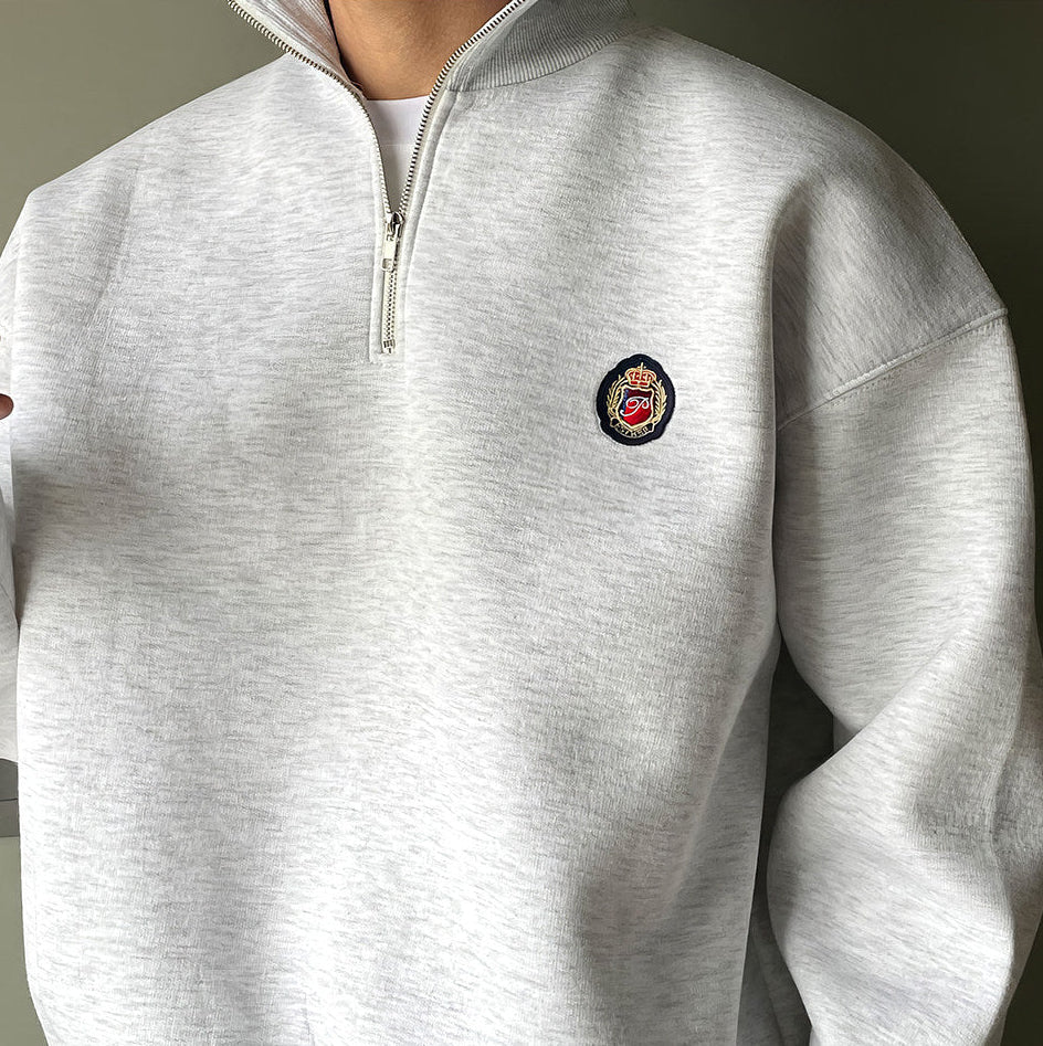 Men's gray high-neck quarter-zip sweatshirt featuring a loose fit, dropped shoulders, and a structured collar.