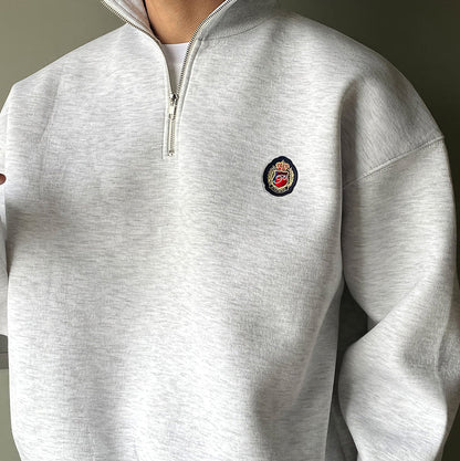 Men's gray high-neck quarter-zip sweatshirt featuring a loose fit, dropped shoulders, and a structured collar.