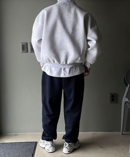 Men's gray high-neck quarter-zip sweatshirt featuring a loose fit, dropped shoulders, and a structured collar.
