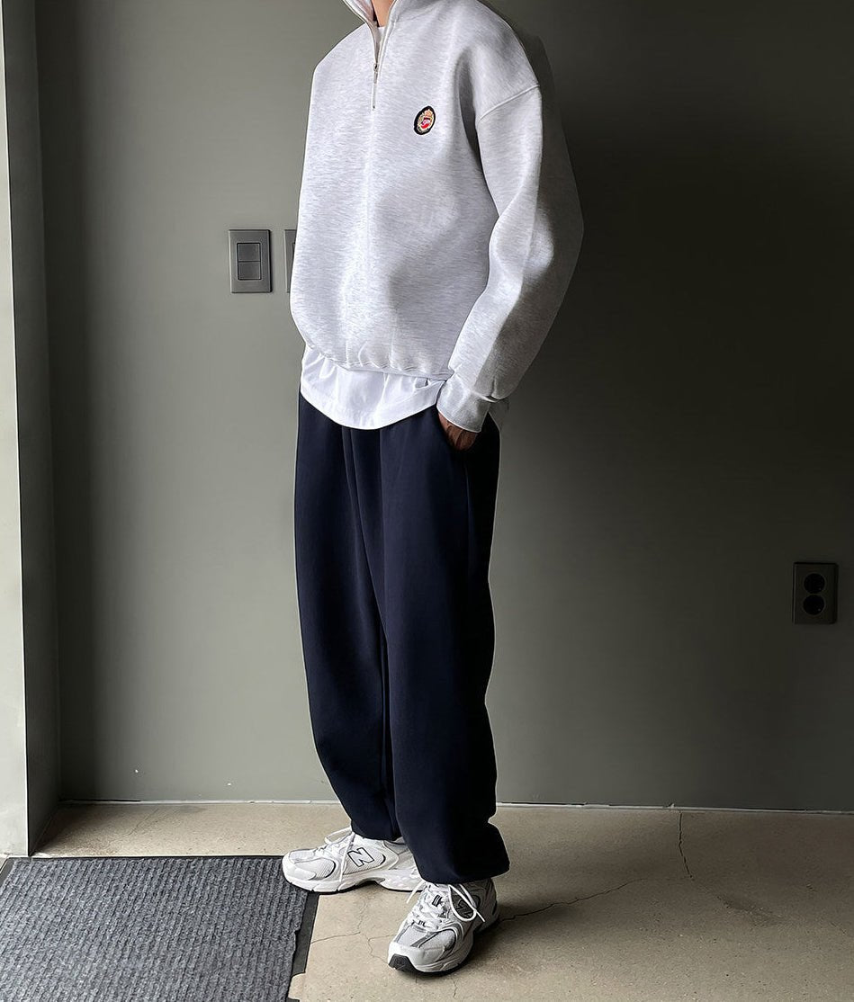 Men's gray high-neck quarter-zip sweatshirt featuring a loose fit, dropped shoulders, and a structured collar.