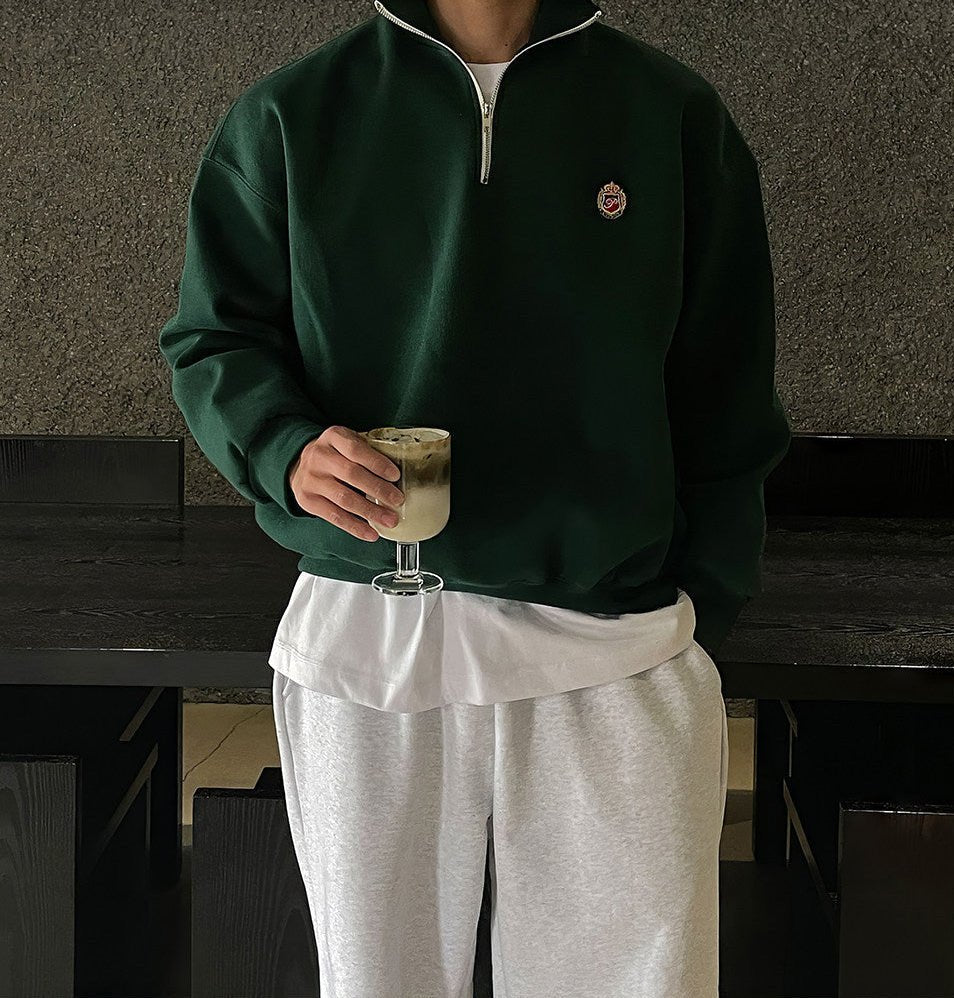 Deep green loose-fit quarter-zip sweatshirt for men with a modern high-neck design and soft-touch finish.