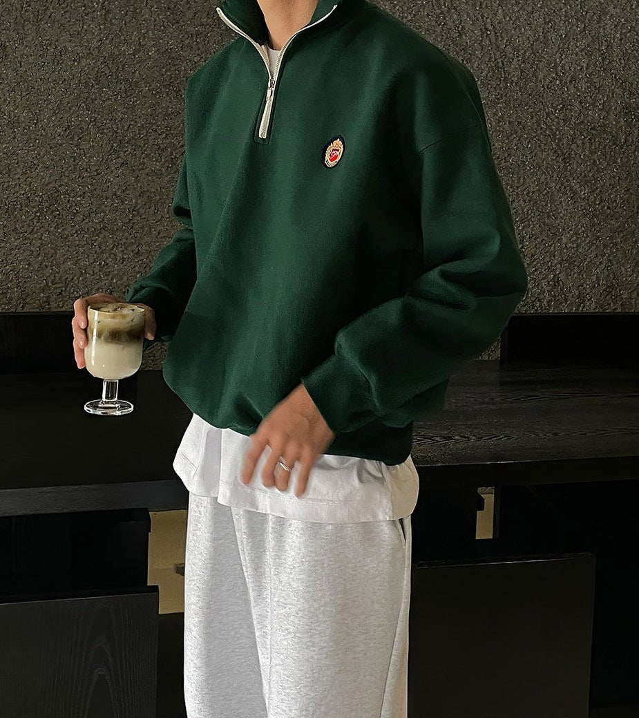 Deep green loose-fit quarter-zip sweatshirt for men with a modern high-neck design and soft-touch finish.