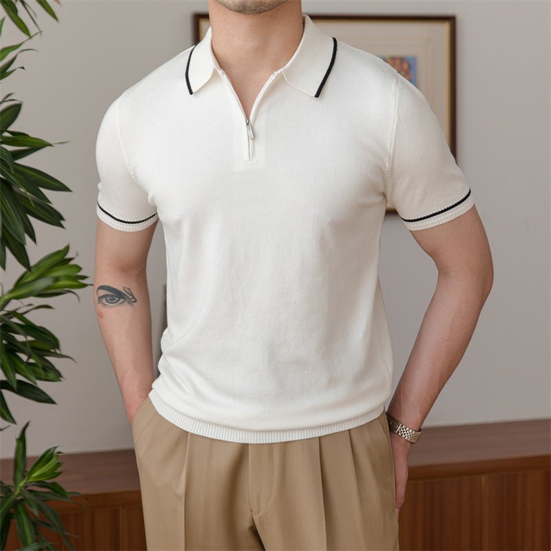Close-up of a white high-gauge knit polo featuring a black tipped collar and a sleek metallic quarter-zip placket.