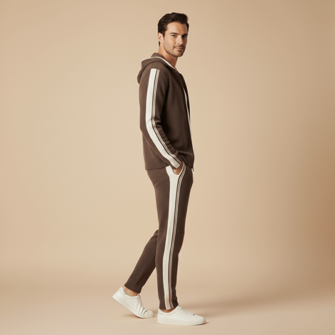 Man wearing a brown tracksuit with white stripes on a beige background