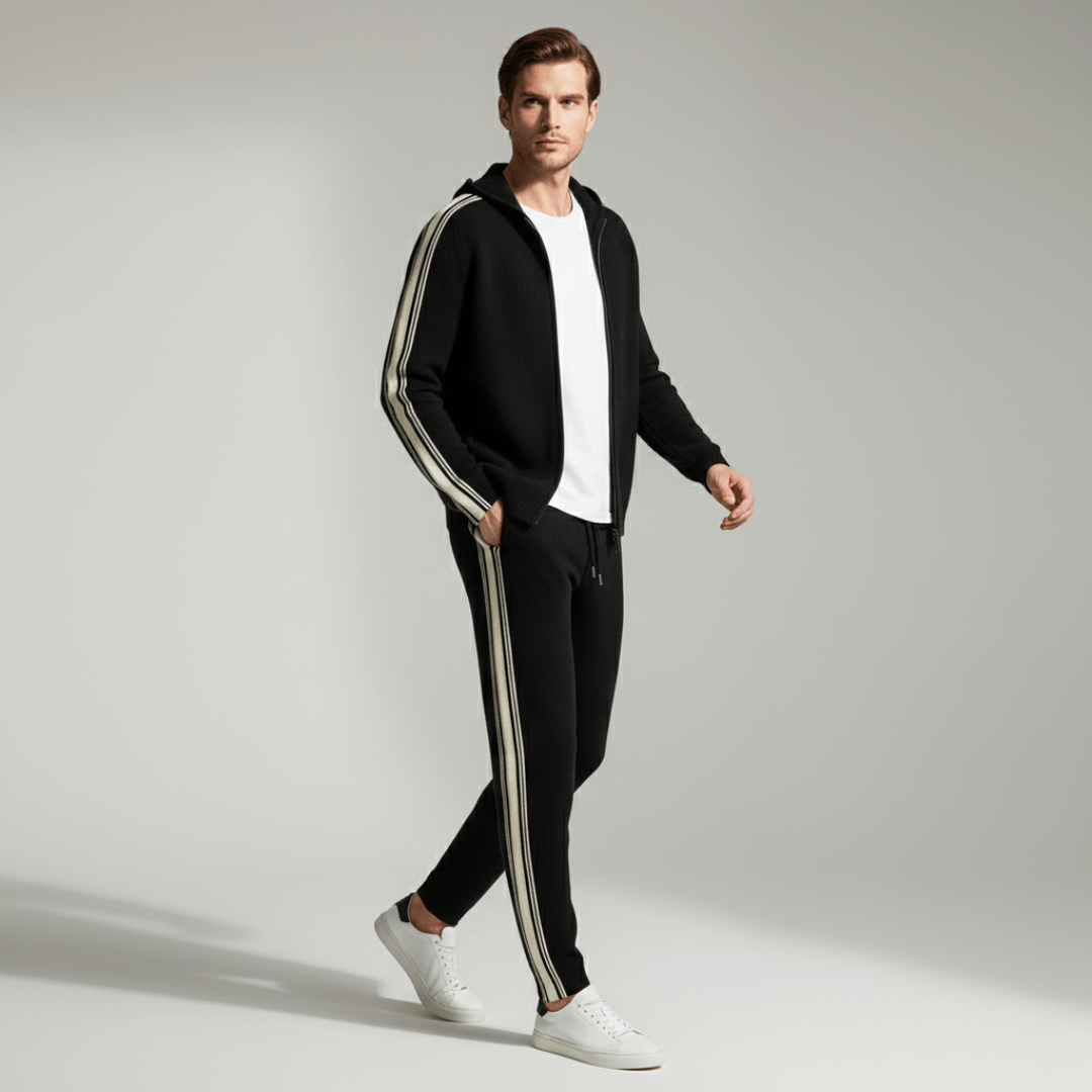 Man wearing a black tracksuit with white stripes on a gray background