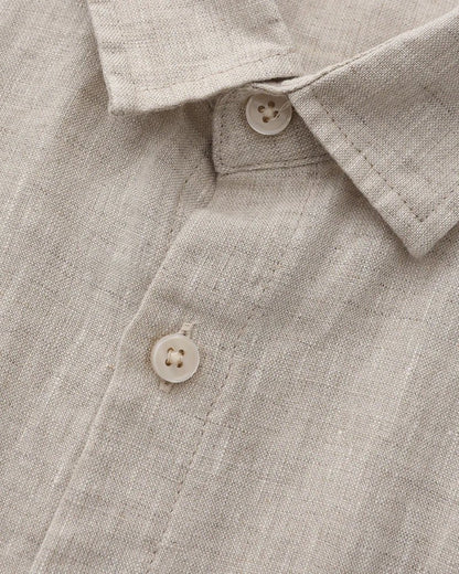 Close-up of a beige linen shirt with buttons and collar details