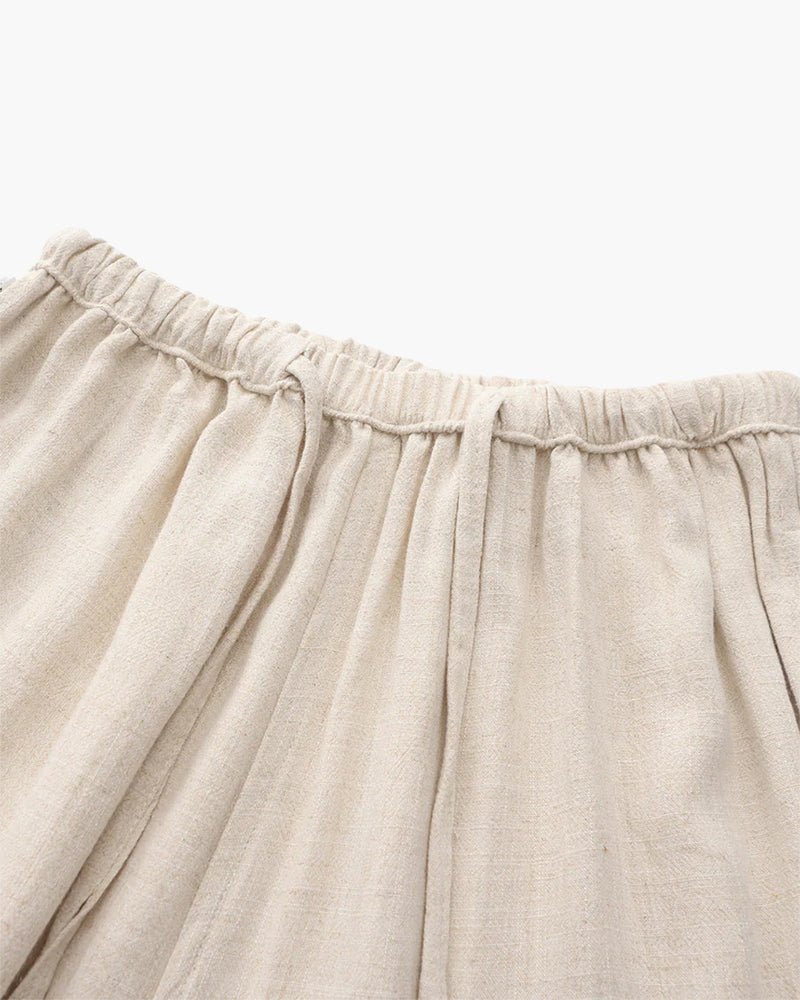 Men's beige straight-leg linen pants featuring a clean structured profile and an adjustable drawstring waistband.