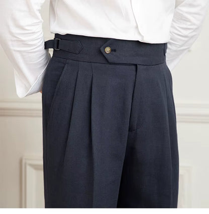Navy pleated pants with a white shirt on a neutral background