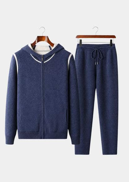 Men's navy blue 100% cashmere set featuring a full-zip hoodie with silver hardware and matching tapered knit pants with a drawstring waist.