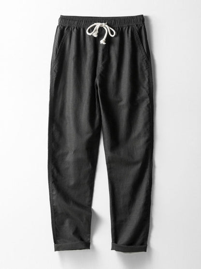 Black pants with a drawstring on a white background