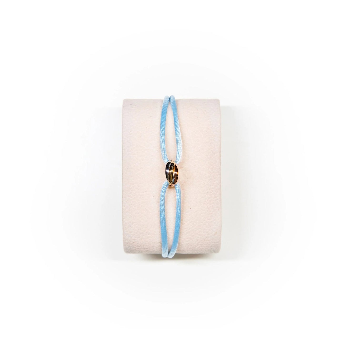 Blue bracelet on a white cushion with a white background
