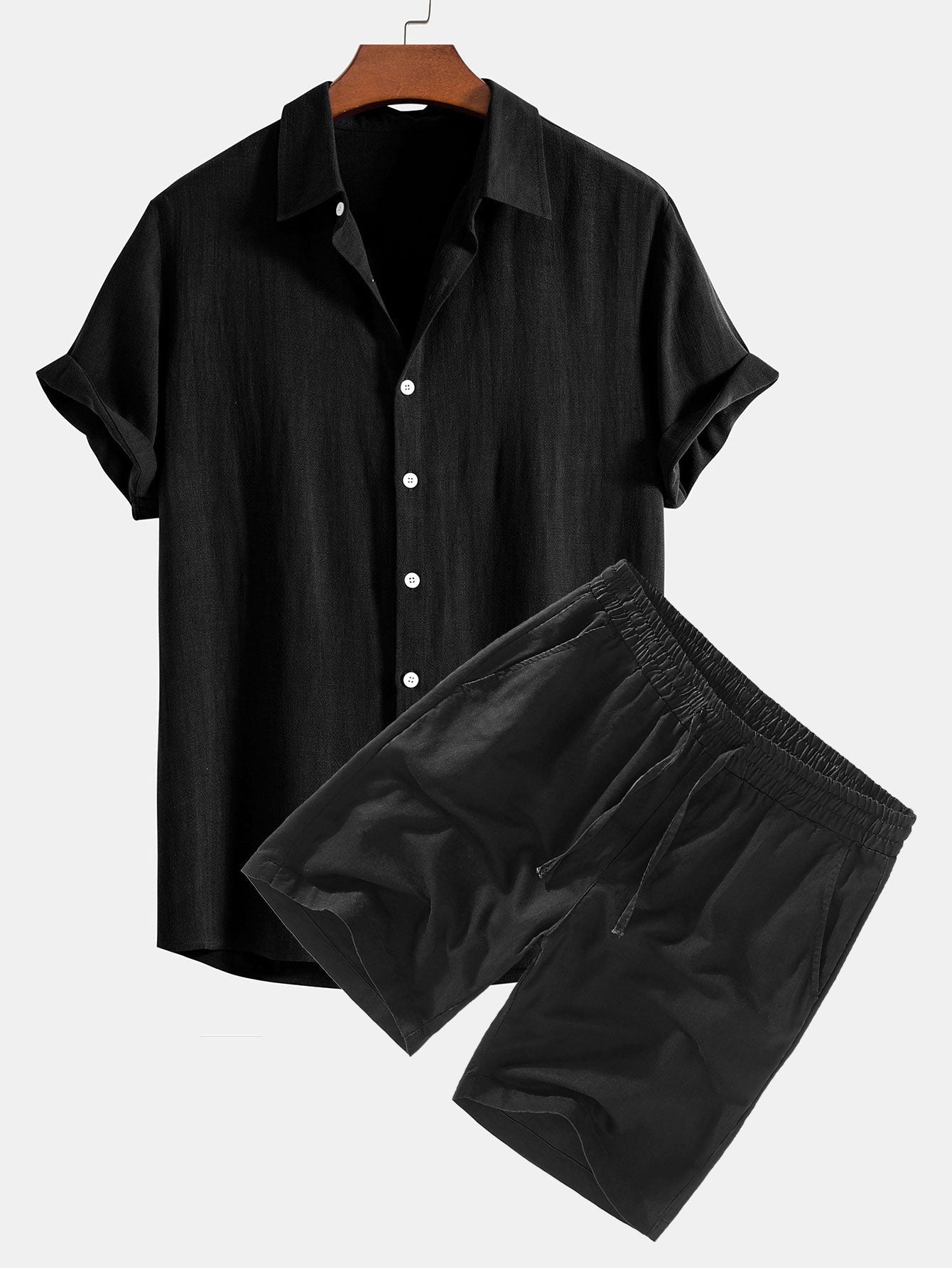 Black shirt and shorts set on a hanger against a white background