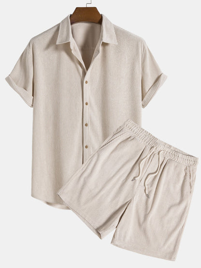 Beige short-sleeve shirt and pants set on a hanger against a white background