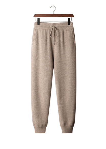 Beige sweatpants on a hanger against a white background