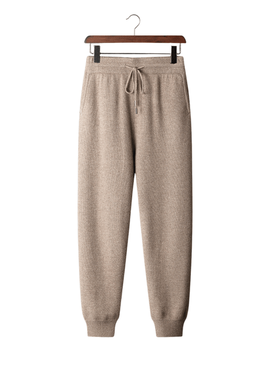 Beige sweatpants on a hanger against a white background